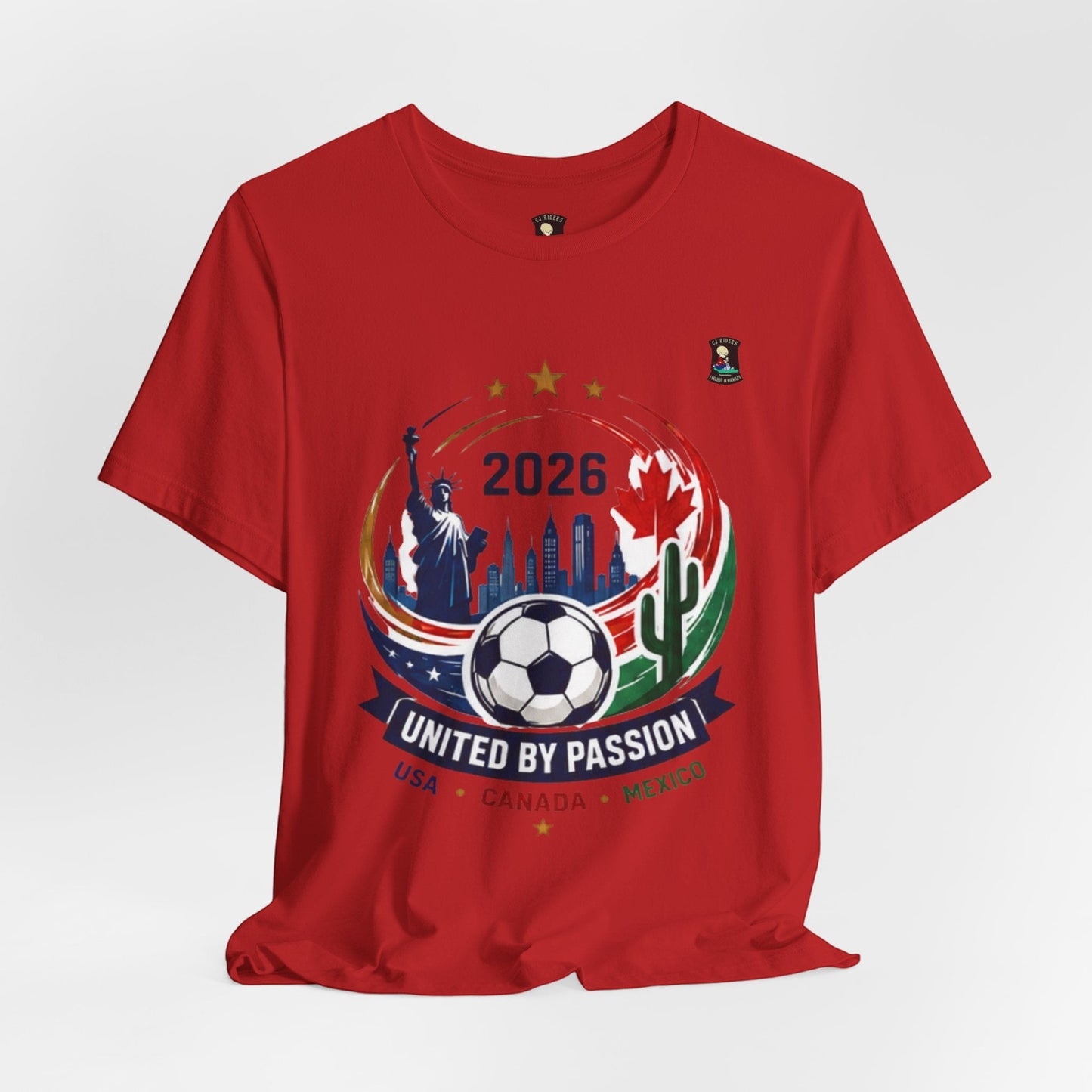 CJ Riders Foundation Store red 100% cotton t-shirt with 2026 soccer graphic featuring Statue of Liberty, Canadian maple leaf, cactus, and soccer ball.