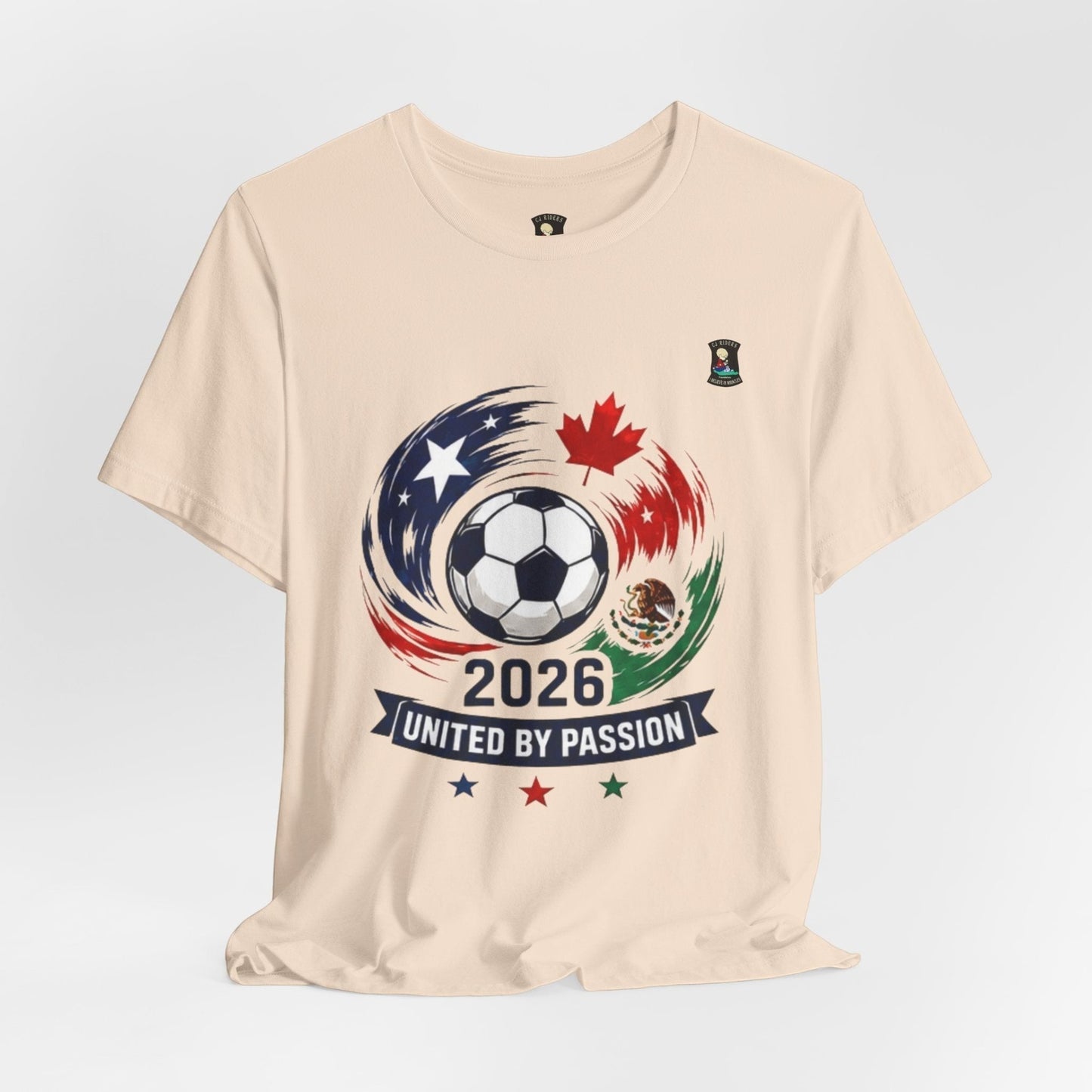 CJ Riders Foundation Store cream 100% cotton t-shirt with 2026 soccer graphic featuring USA, Canada, Mexico flags and "United by Passion" text.