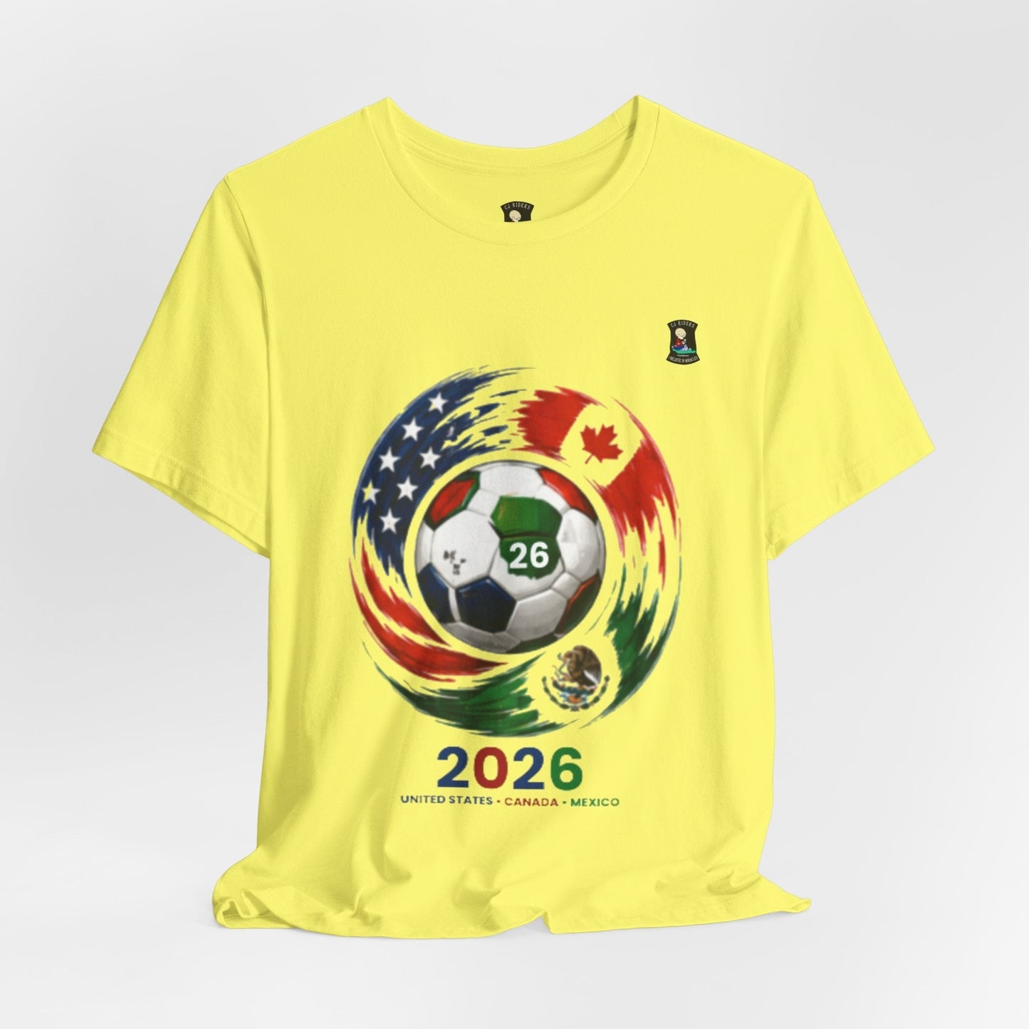 CJ Riders Foundation Store yellow 100% cotton t-shirt with 2026 World Cup graphic featuring a soccer ball and flags of USA, Canada, and Mexico.