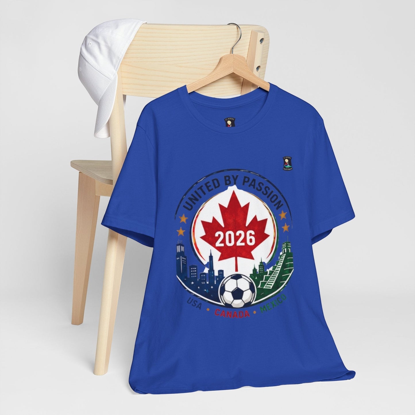 CJ Riders Foundation Store blue 100% cotton t-shirt with 2026 soccer crest design featuring Canada, USA, Mexico, and a soccer ball.