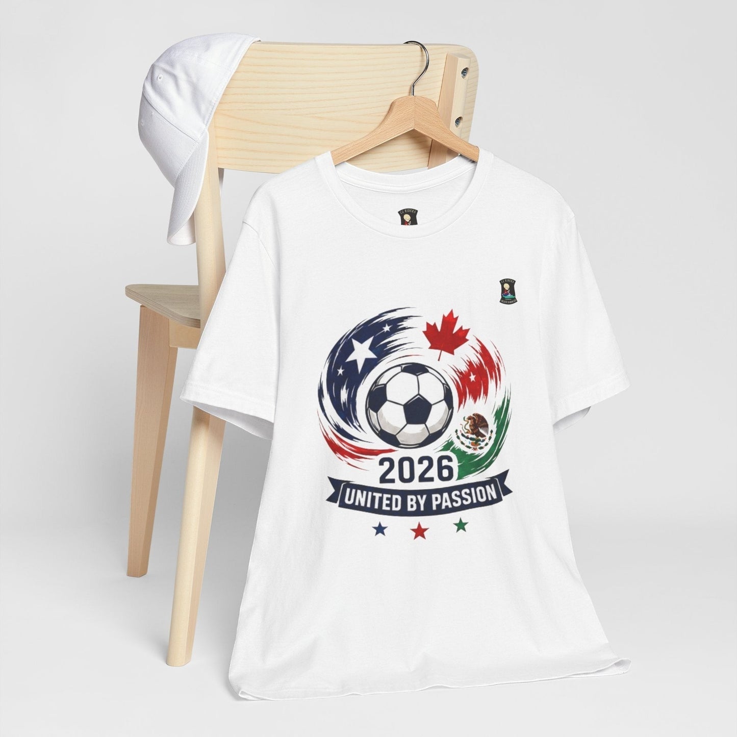 CJ Riders Foundation Store white 100% cotton t-shirt with 2026 soccer graphic featuring USA, Canada, Mexico flags and a soccer ball.