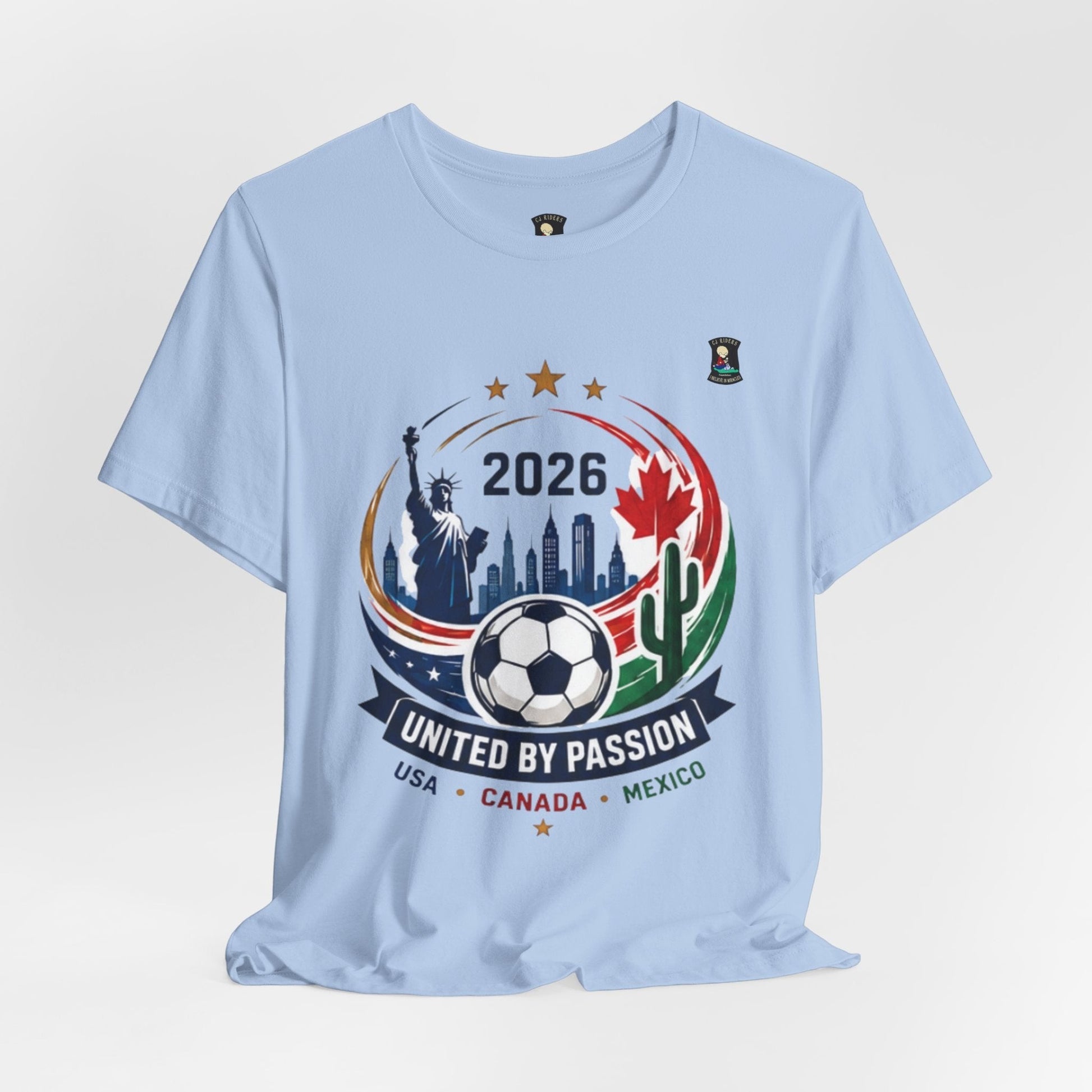 CJ Riders Foundation Store light blue 100% cotton t-shirt with 2026 soccer graphic featuring USA, Canada, Mexico landmarks and soccer ball.