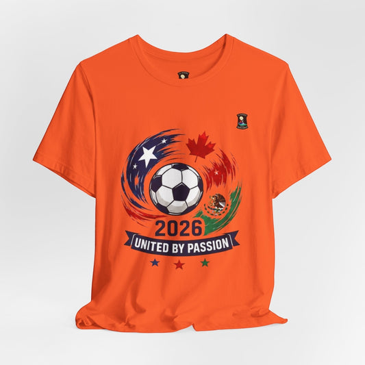 CJ Riders Foundation Store orange 100% cotton t-shirt with 2026 soccer graphic featuring USA, Canada, Mexico flags and a soccer ball.
