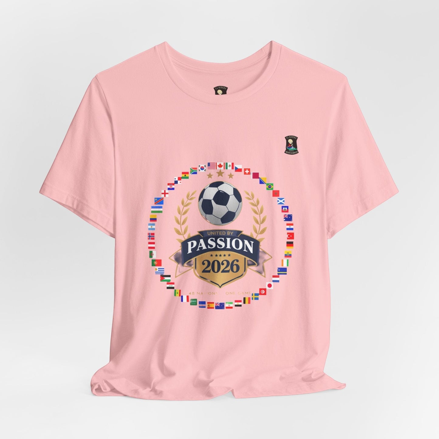 CJ Riders Foundation Store pink 100% cotton t-shirt with 2026 World Cup graphic featuring flags, soccer ball, and "United by Passion" text.