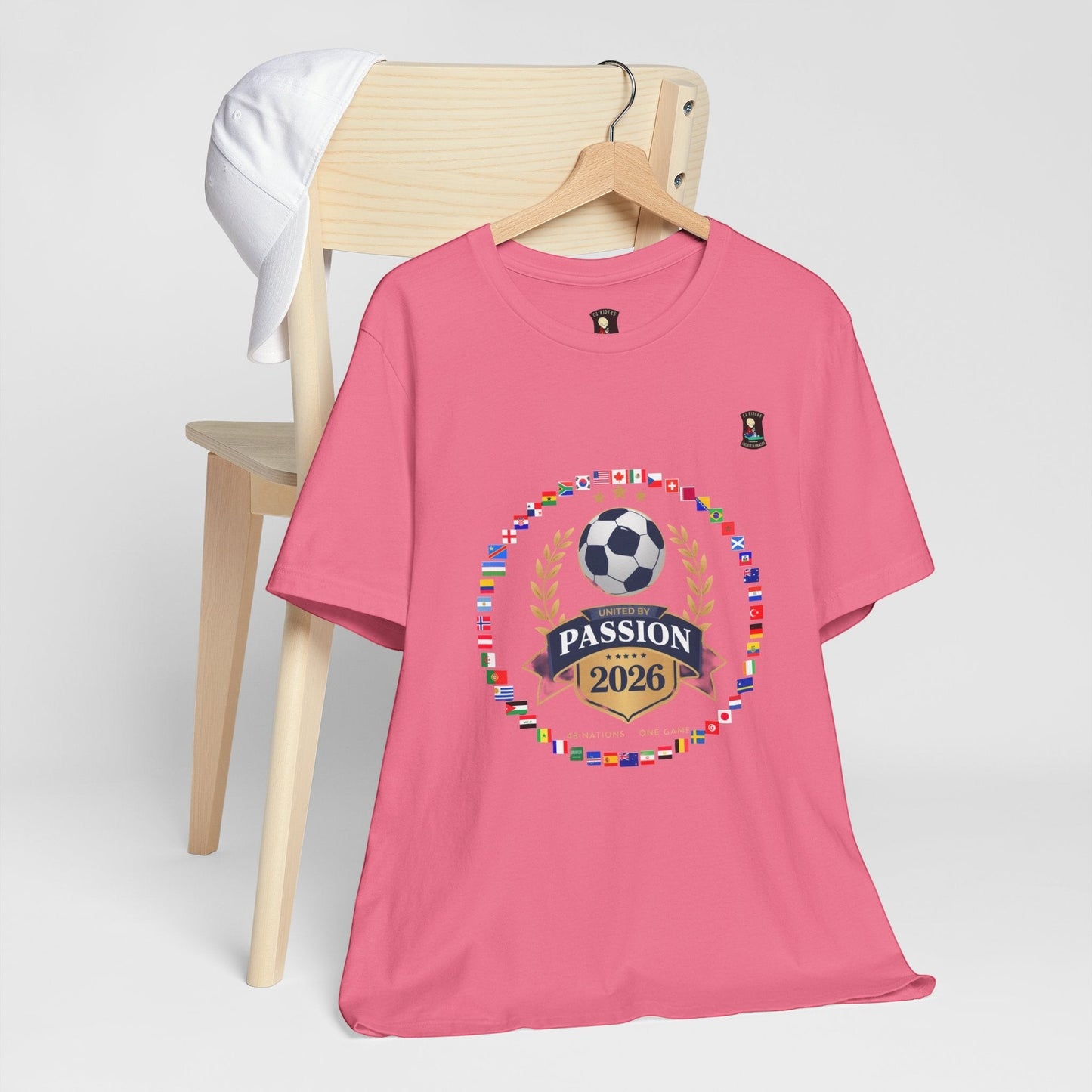 CJ Riders Foundation Store pink 100% cotton t-shirt with 2026 soccer graphic and international flags.