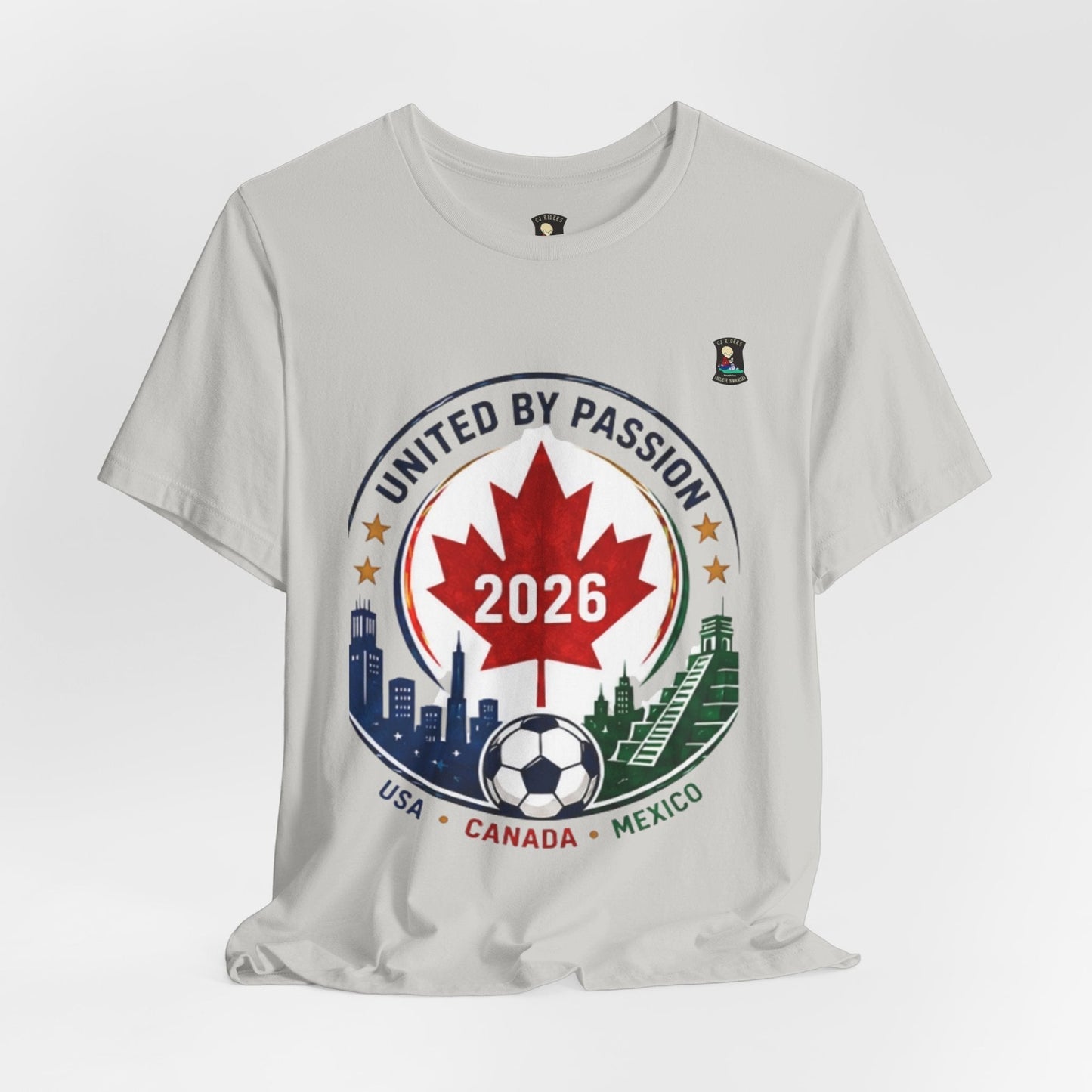 CJ Riders Foundation Store light grey 100% cotton t-shirt with a circular graphic celebrating the 2026 World Cup, featuring a Canadian maple leaf, soccer ball, and city skylines.