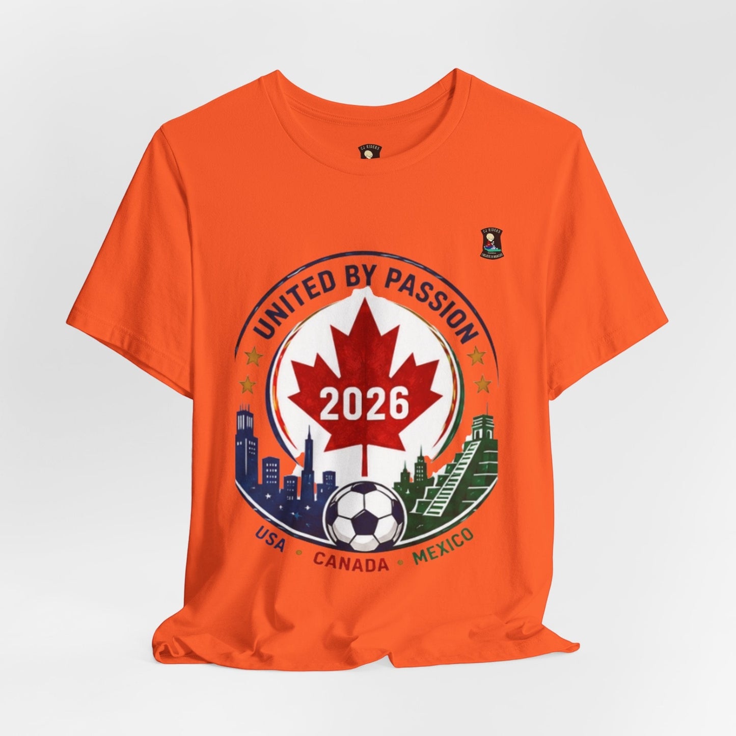 CJ Riders Foundation Store orange 100% cotton t-shirt with a soccer crest design for 2026, featuring a maple leaf, soccer ball, and city skylines.