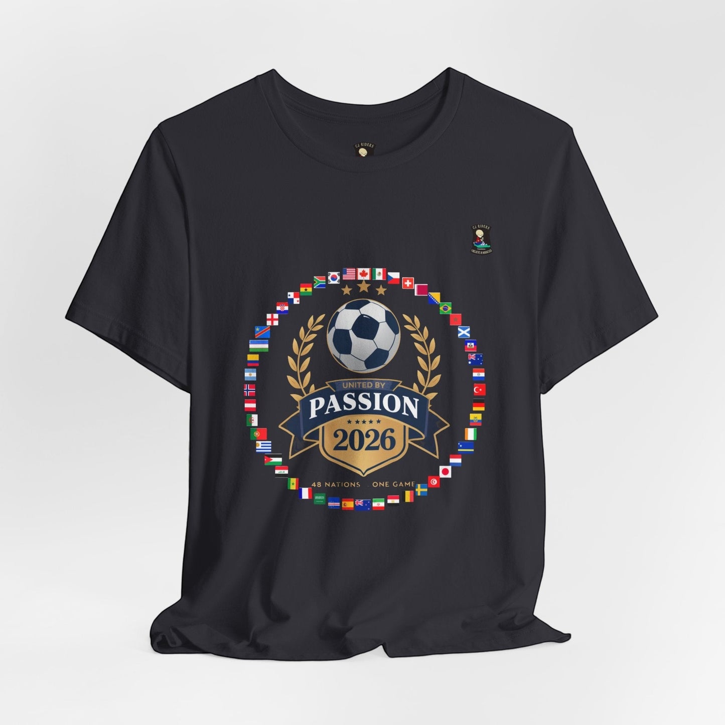 CJ Riders Foundation Store dark grey 100% cotton t-shirt with 2026 World Cup graphic featuring a soccer ball, flags, and "United by Passion" text.