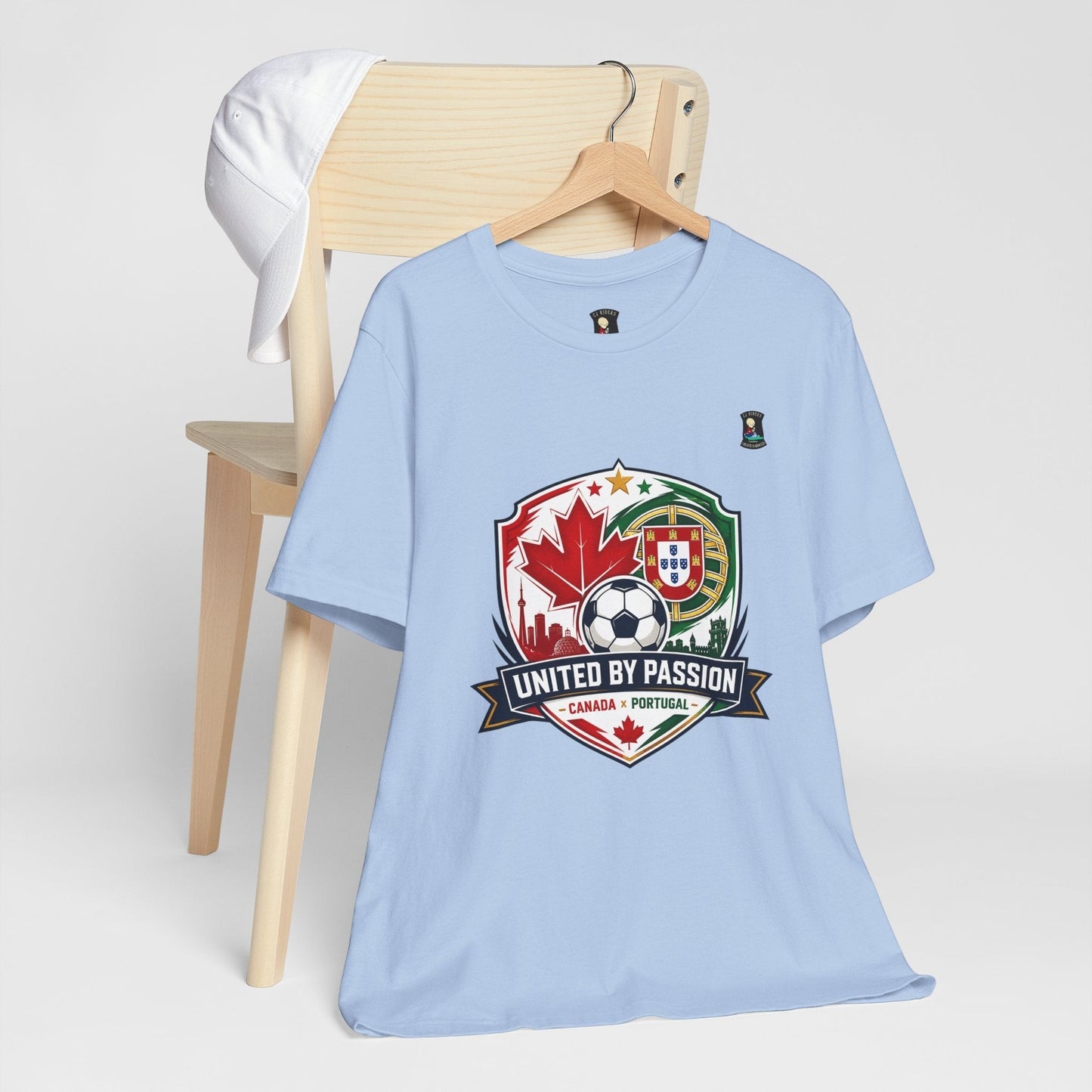 CJ Riders Foundation Store light blue 100% cotton t-shirt with Canada & Portugal soccer crest and "United by Passion" text.