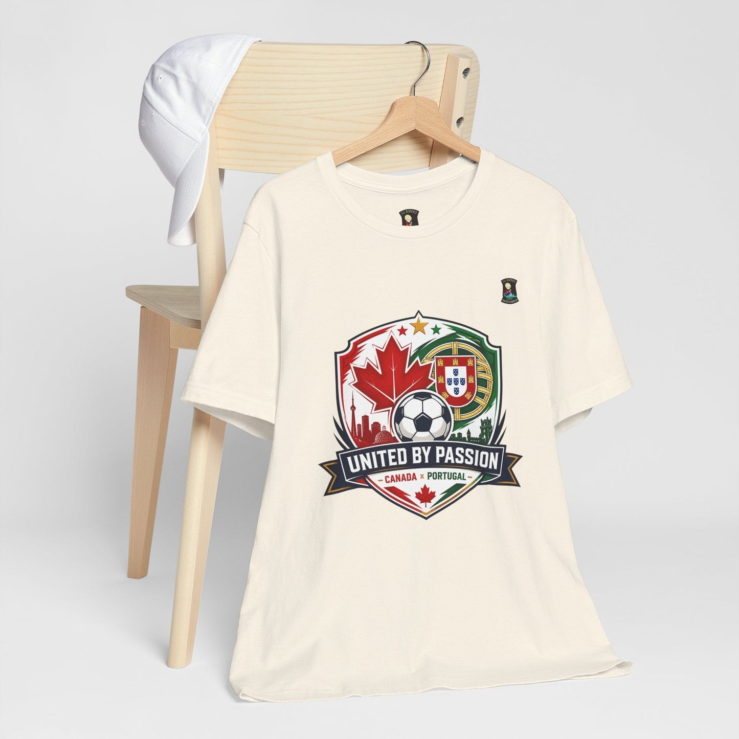 CJ Riders Foundation Store cream 100% cotton t-shirt with Canada & Portugal soccer badge graphic.