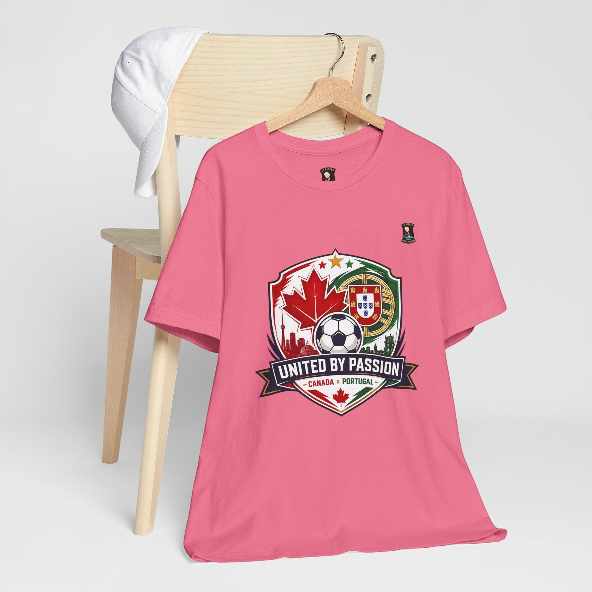 CJ Riders Foundation Store pink 100% cotton t-shirt with Canada & Portugal soccer badge graphic. Features "United by Passion" text.