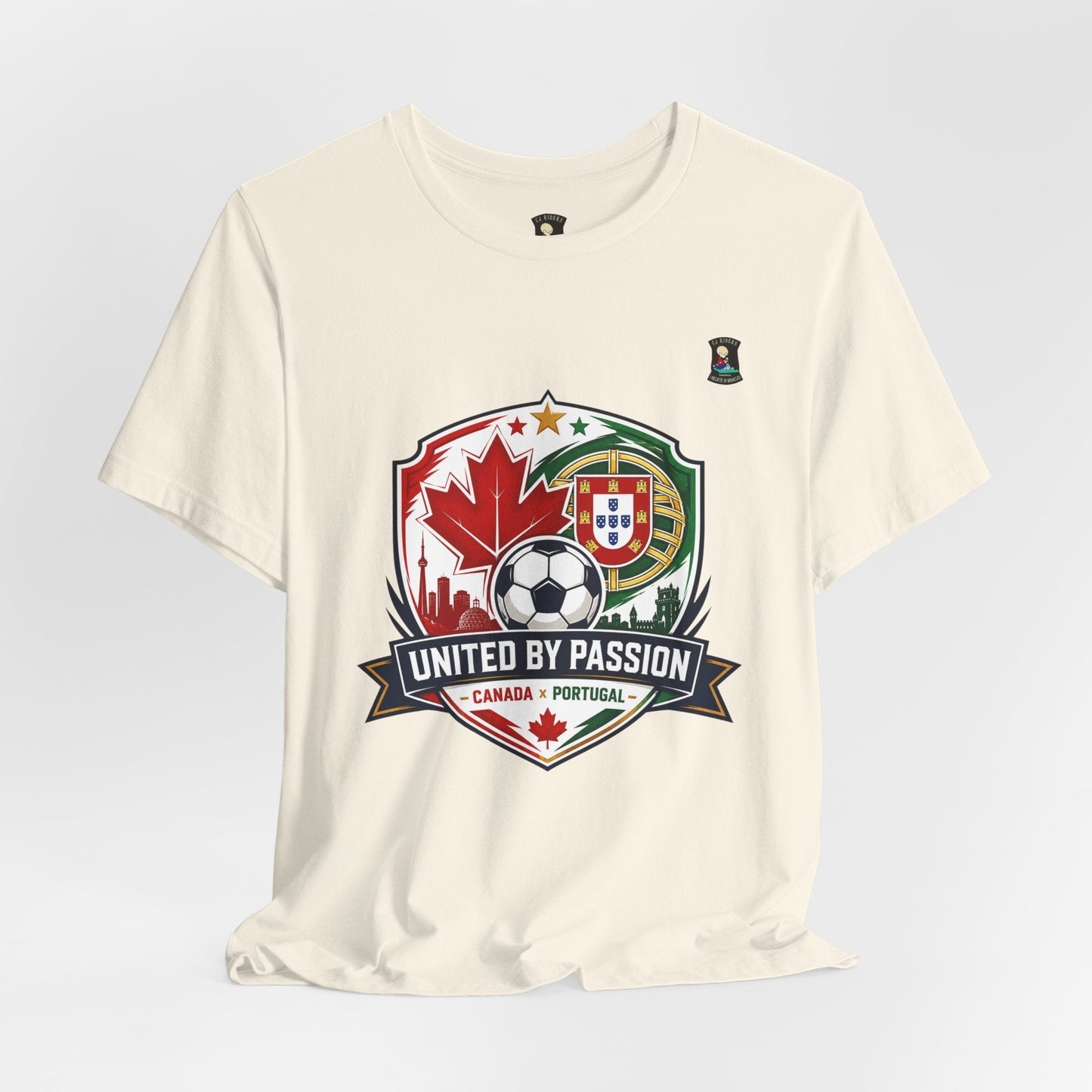CJ Riders Foundation Store cream 100% cotton t-shirt with a soccer badge graphic featuring Canadian and Portuguese flags, a soccer ball, and the text "United by Passion".