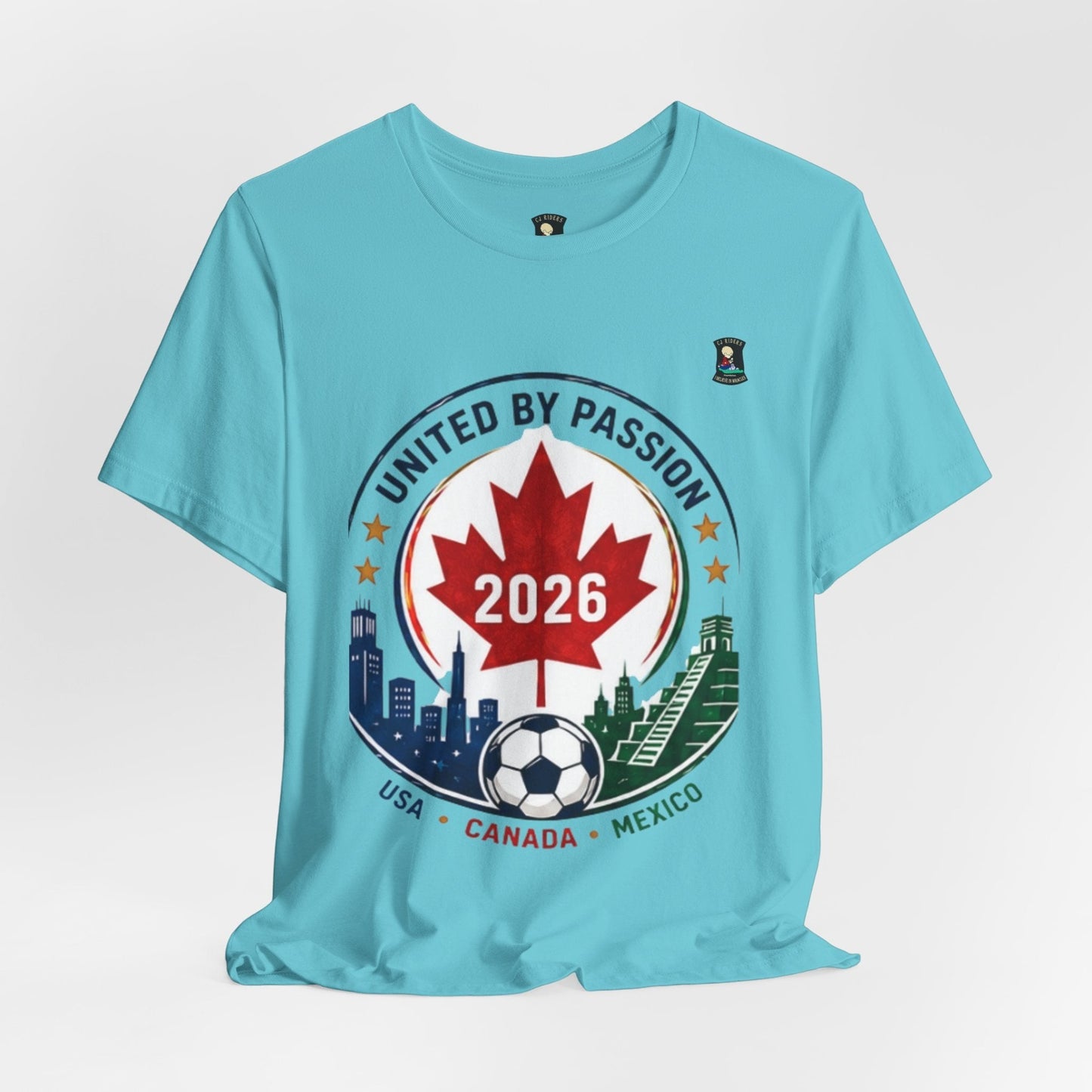 CJ Riders Foundation Store light blue 100% cotton t-shirt with a soccer crest design featuring a Canadian maple leaf, 2026, and city skylines.