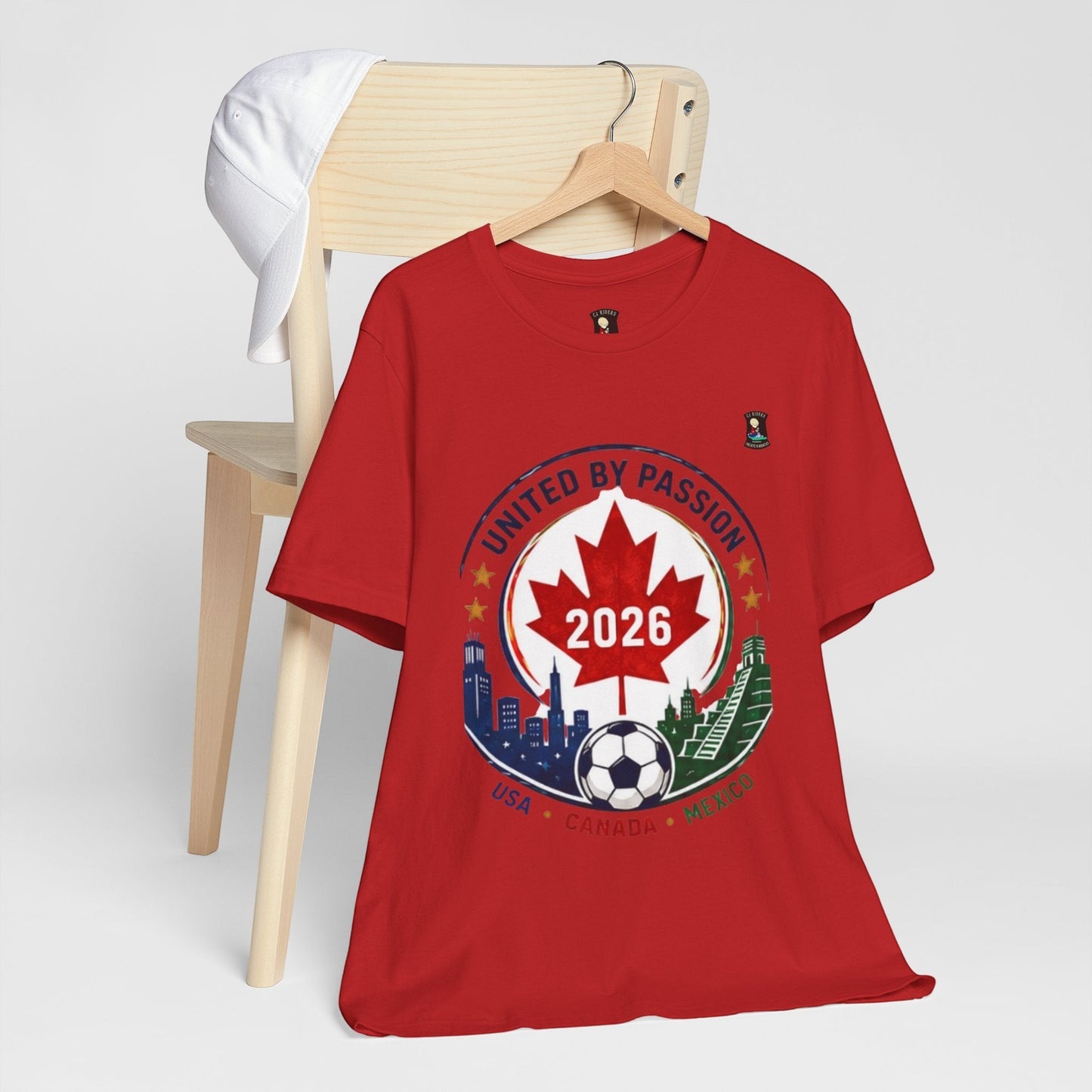 CJ Riders Foundation Store red cotton t-shirt with "United by Passion 2026" soccer crest design featuring Canada, USA, Mexico landmarks.