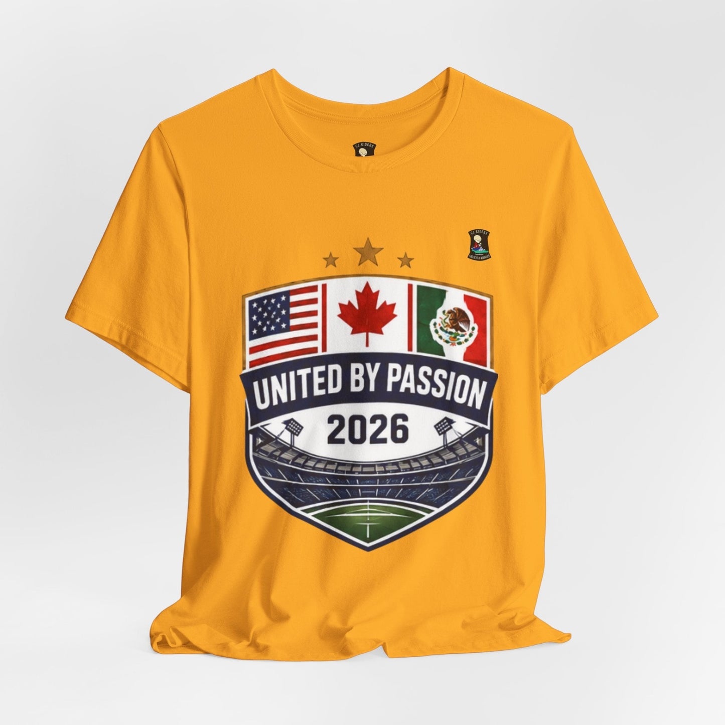 CJ Riders Foundation Store yellow 100% cotton t-shirt with United by Passion 2026 shield design featuring US, Canada, Mexico flags and stadium.