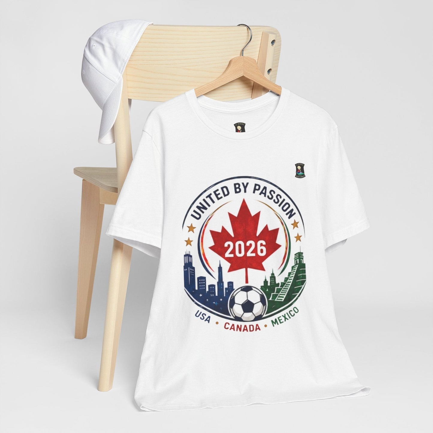 CJ Riders Foundation Store white cotton t-shirt with "United by Passion 2026" soccer crest design featuring maple leaf, soccer ball, and city skylines.