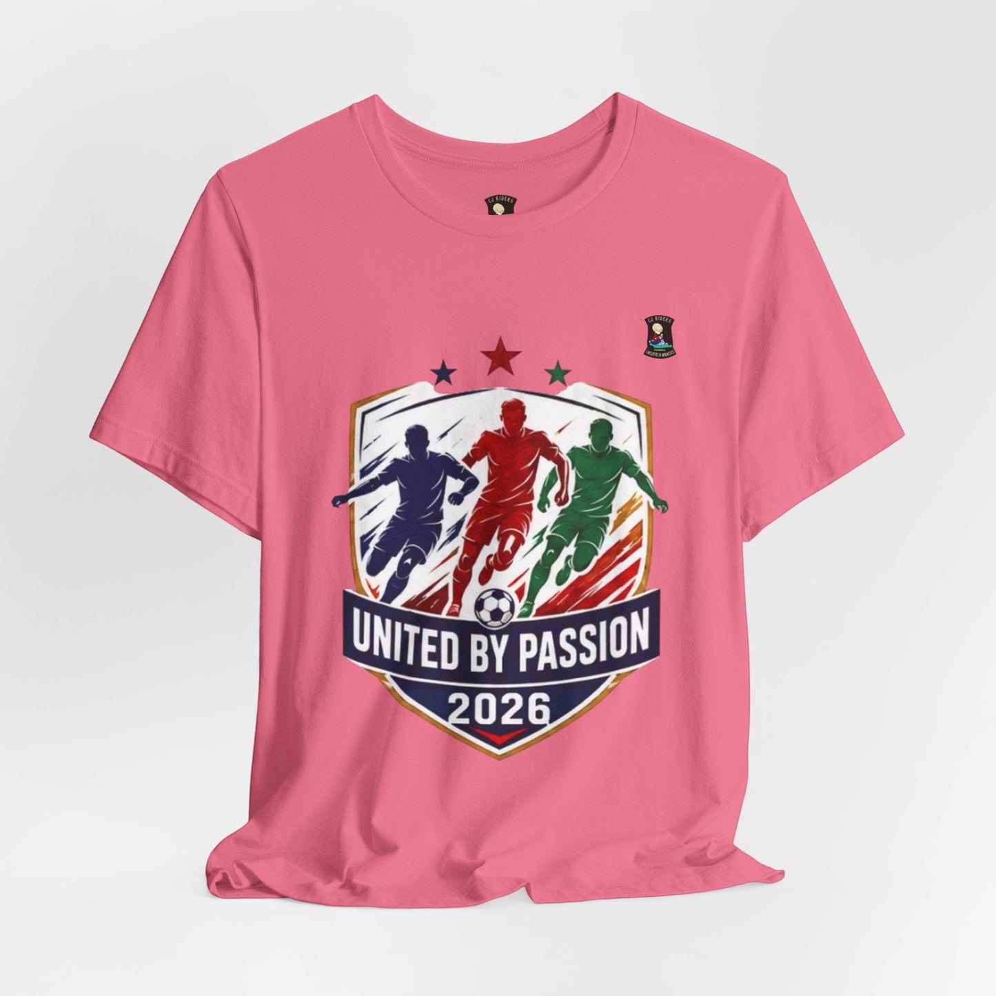 CJ Riders Foundation Store pink cotton t-shirt with "United by Passion 2026" soccer graphic featuring three players and a ball.