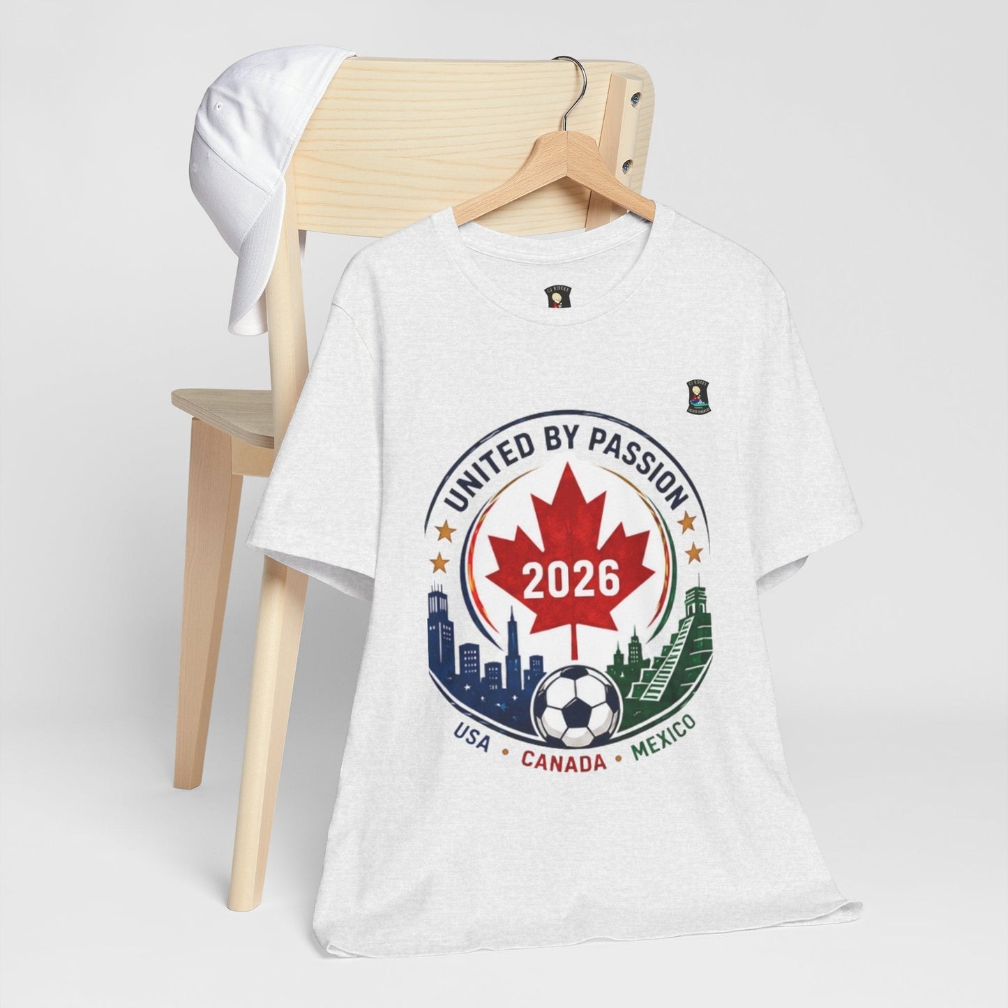 CJ Riders Foundation Store white 100% cotton t-shirt with United by Passion 2026 soccer graphic featuring Canada's maple leaf and city skylines.