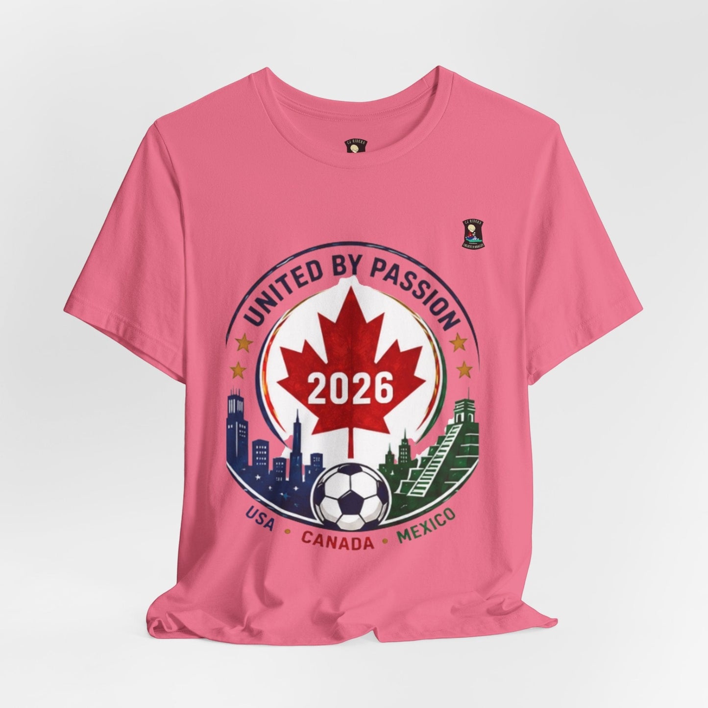 CJ Riders Foundation Store pink cotton t-shirt with United by Passion 2026 soccer graphic featuring Canadian maple leaf, soccer ball, and city skylines.