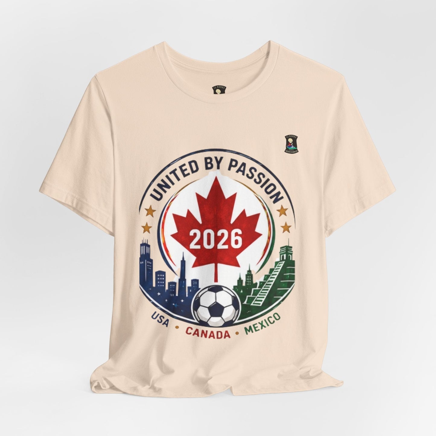 CJ Riders Foundation Store cream 100% cotton t-shirt with United by Passion 2026 soccer graphic featuring Canadian maple leaf, soccer ball, and city skylines.
