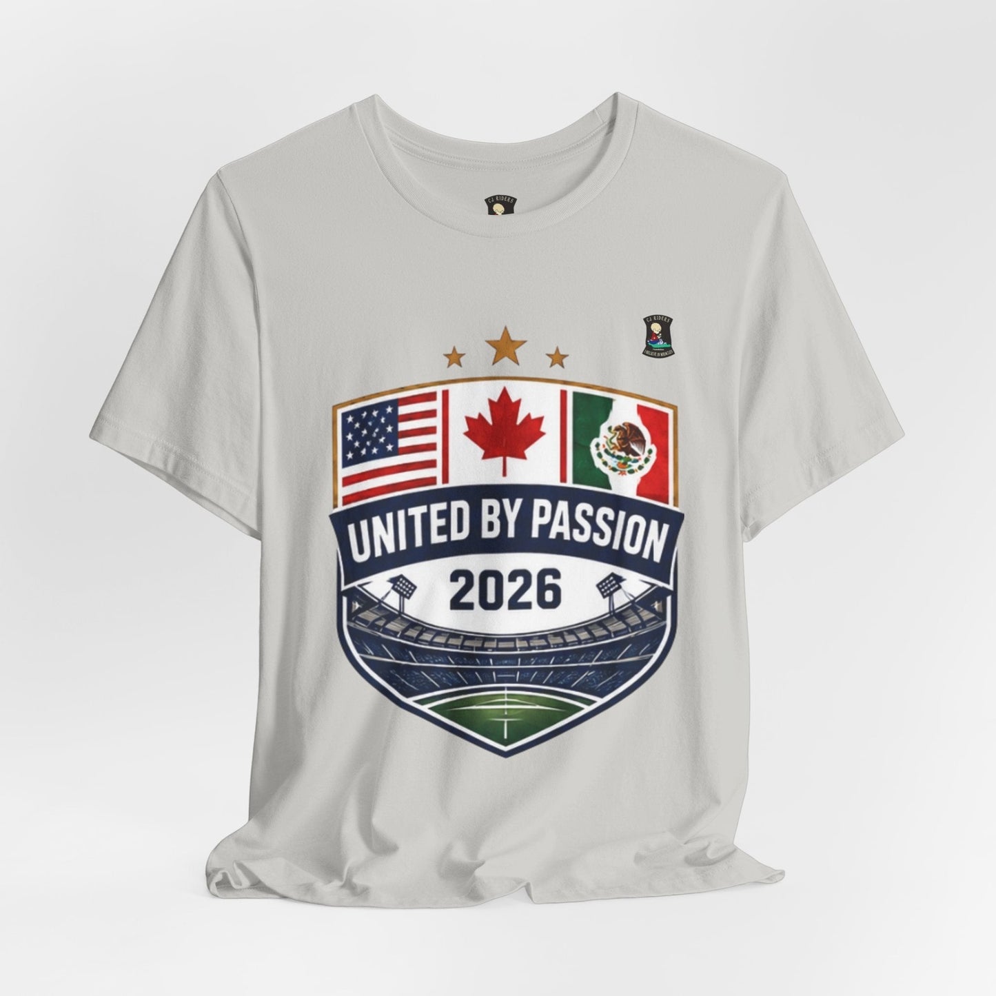 CJ Riders Foundation Store light grey 100% cotton t-shirt with United by Passion 2026 shield design featuring USA, Canada, and Mexico flags.