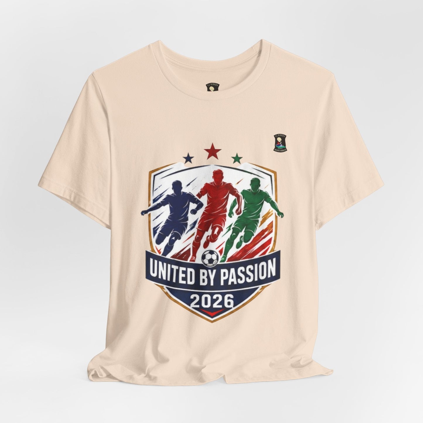 CJ Riders Foundation Store cream 100% cotton t-shirt with "United by Passion 2026" soccer graphic featuring 3 players and a ball.