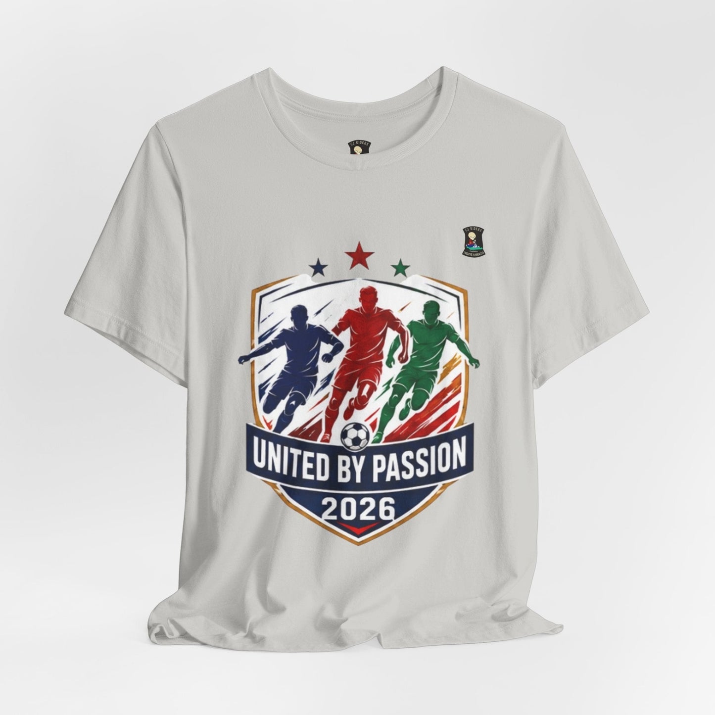 CJ Riders Foundation Store light grey 100% cotton t-shirt with "United by Passion 2026" graphic featuring 3 soccer players.