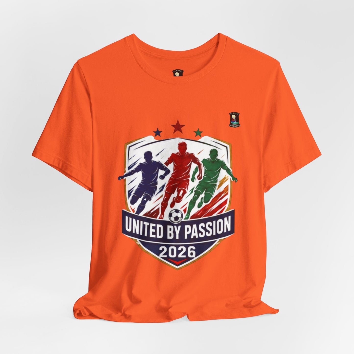 CJ Riders Foundation Store orange 100% cotton t-shirt with "United by Passion 2026" graphic featuring 3 soccer players and a ball.