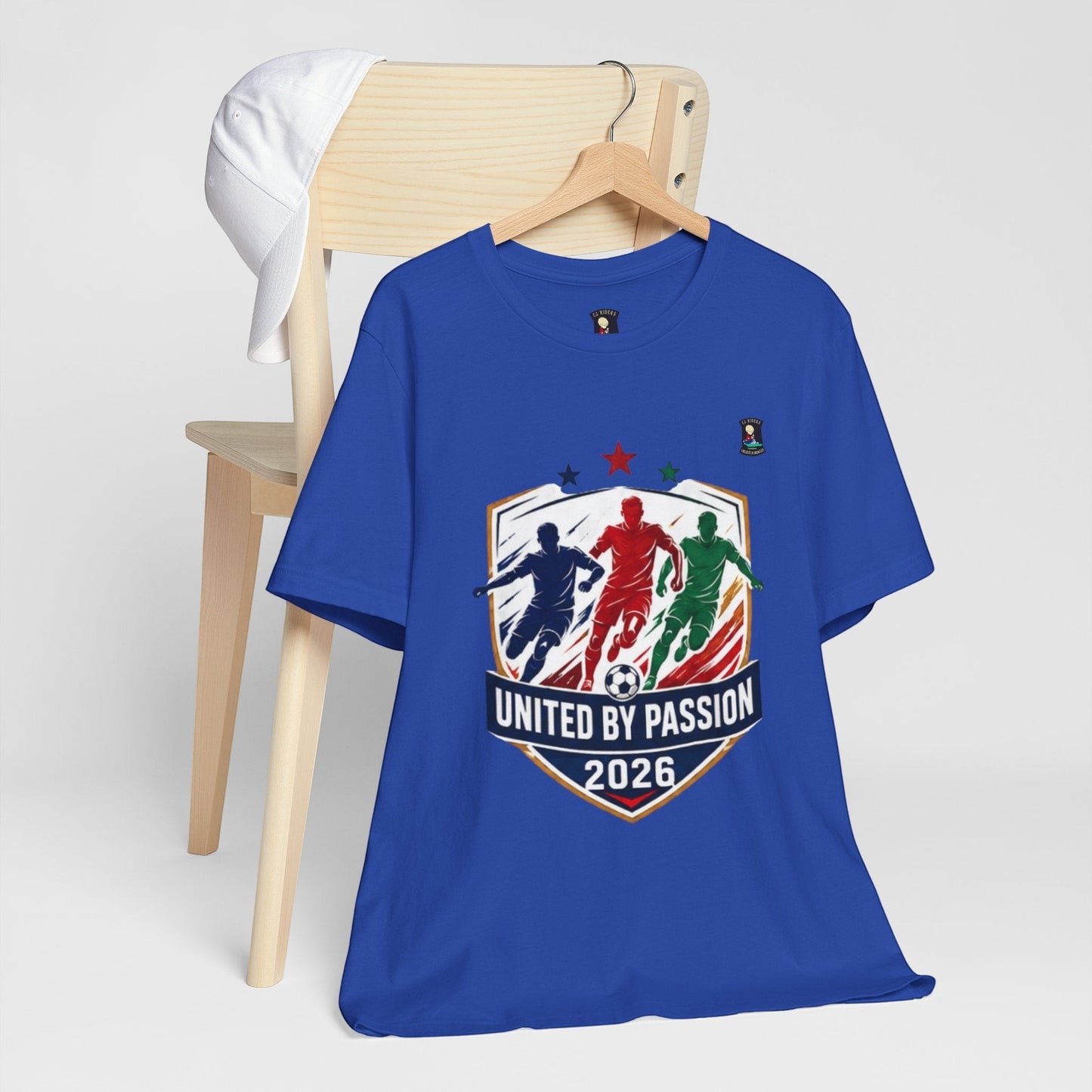 CJ Riders Foundation Store blue 100% cotton t-shirt with "United by Passion 2026" soccer graphic.