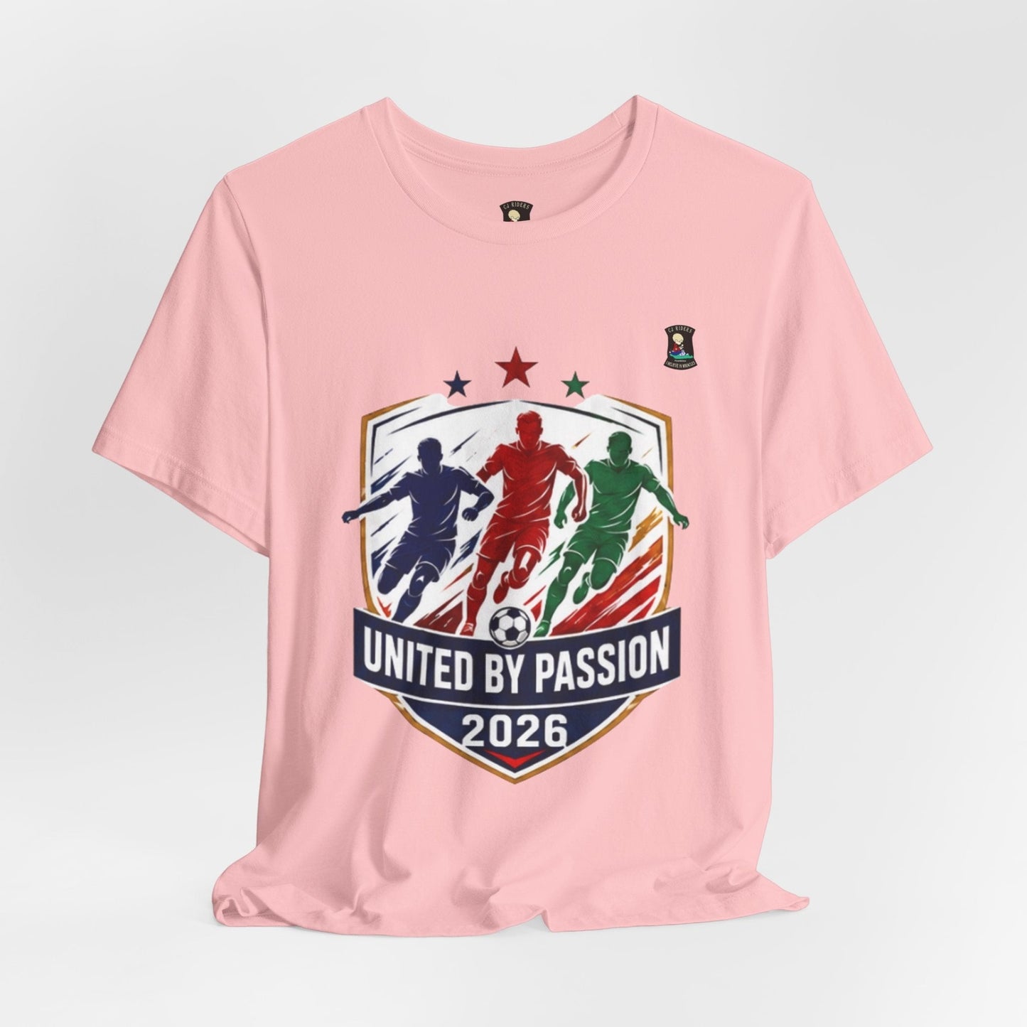 CJ Riders Foundation Store pink 100% cotton t-shirt with "United by Passion 2026" soccer graphic featuring 3 footballers.