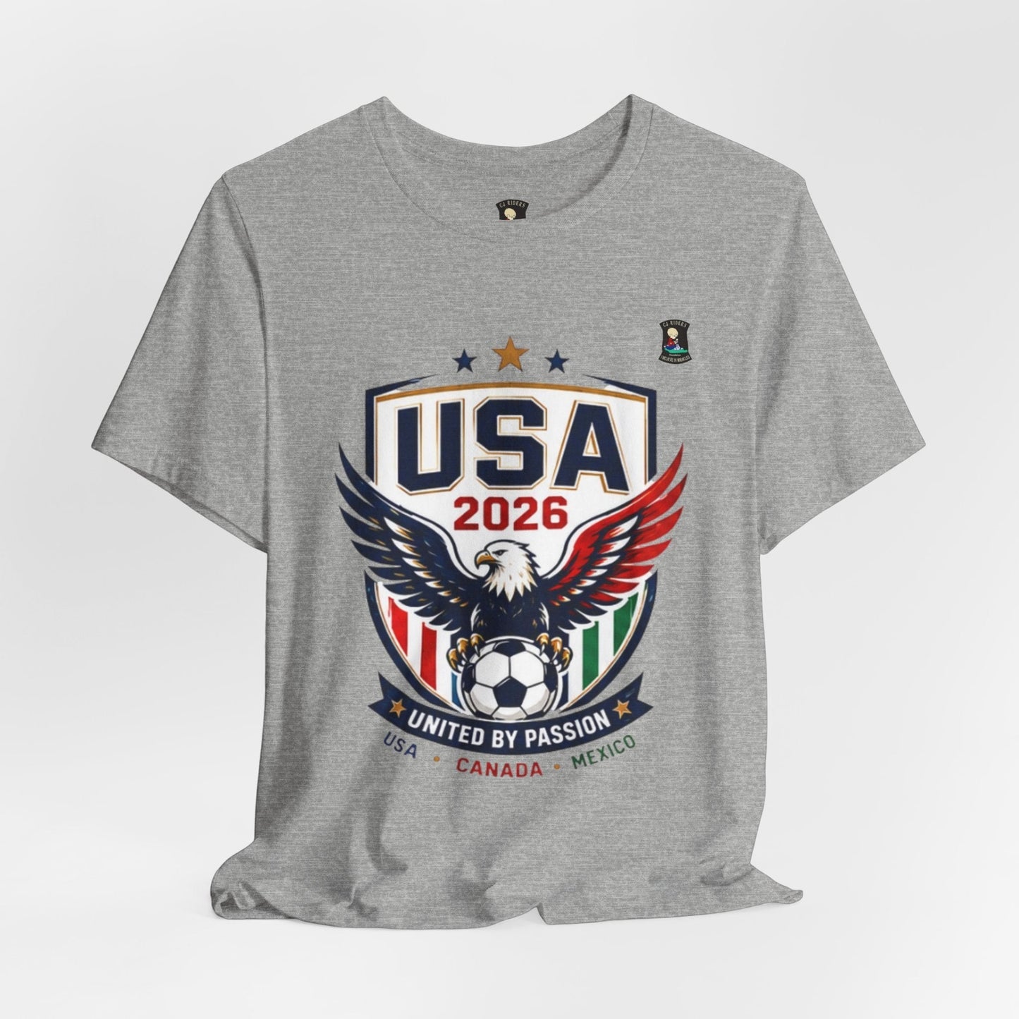 CJ Riders Foundation Store grey 100% cotton t-shirt with USA 2026 eagle and soccer graphic. Features patriotic colors and