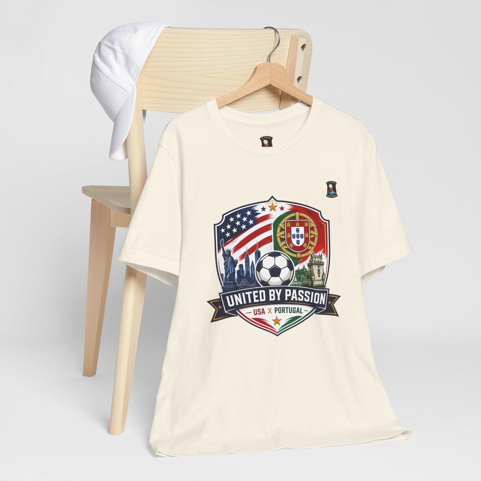CJ Riders Foundation Store cream 100% cotton t-shirt with USA & Portugal soccer graphic and "United by Passion" text.