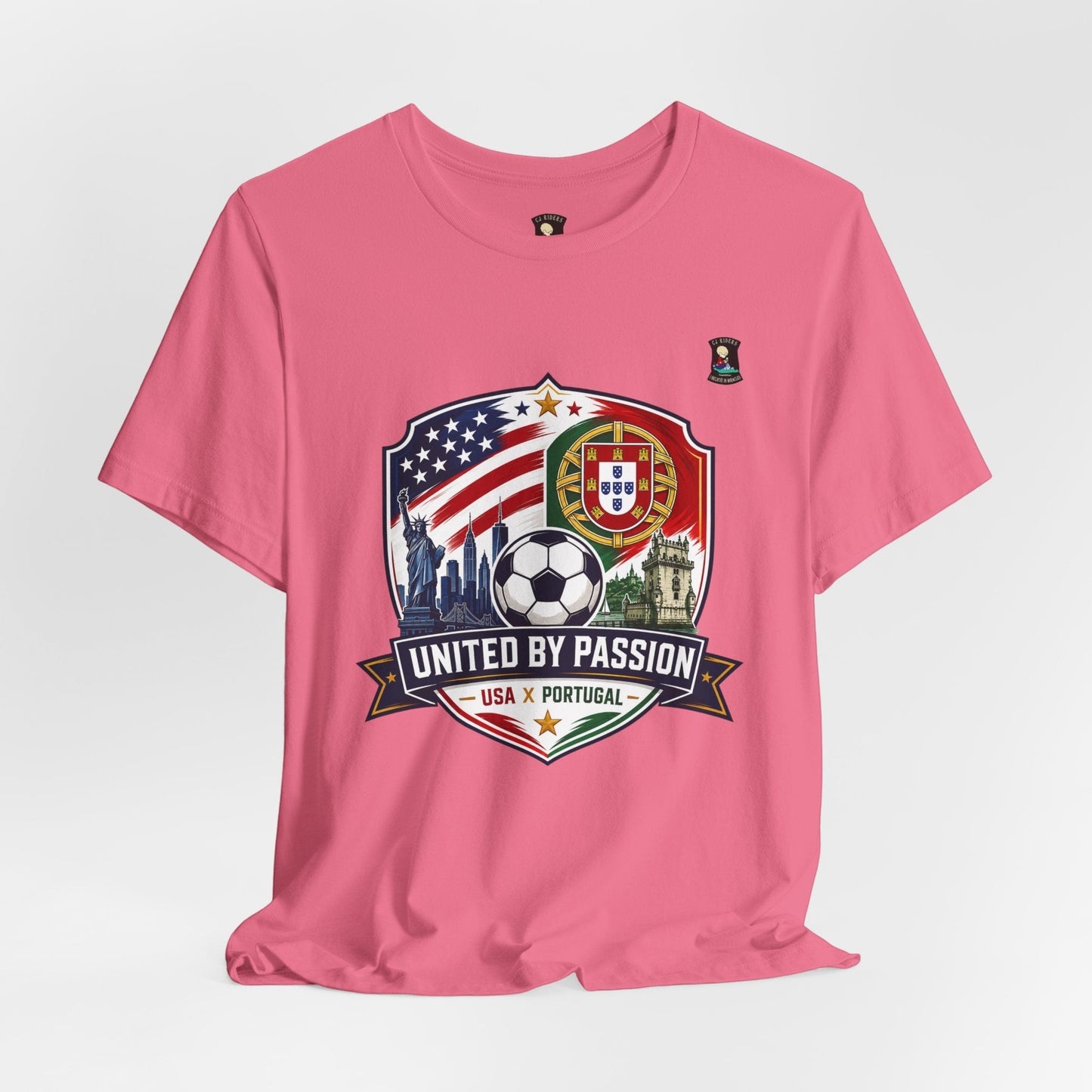 CJ Riders Foundation Store pink cotton t-shirt with USA & Portugal soccer badge, Statue of Liberty, skyline, and soccer ball.