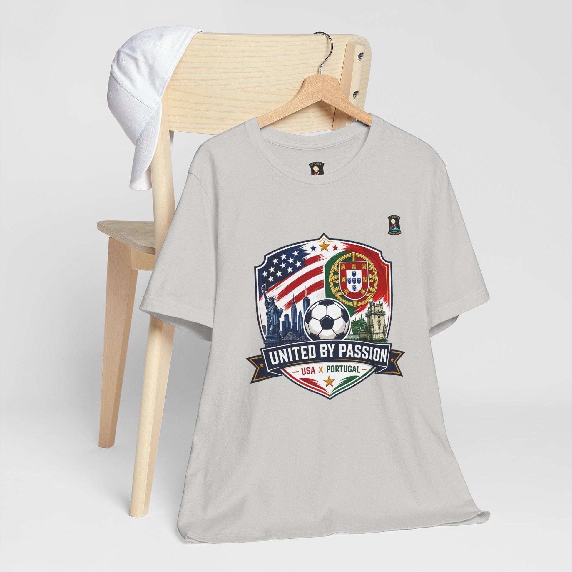 CJ Riders Foundation Store light grey 100% cotton t-shirt with USA & Portugal soccer crest graphic and "United by Passion" text.