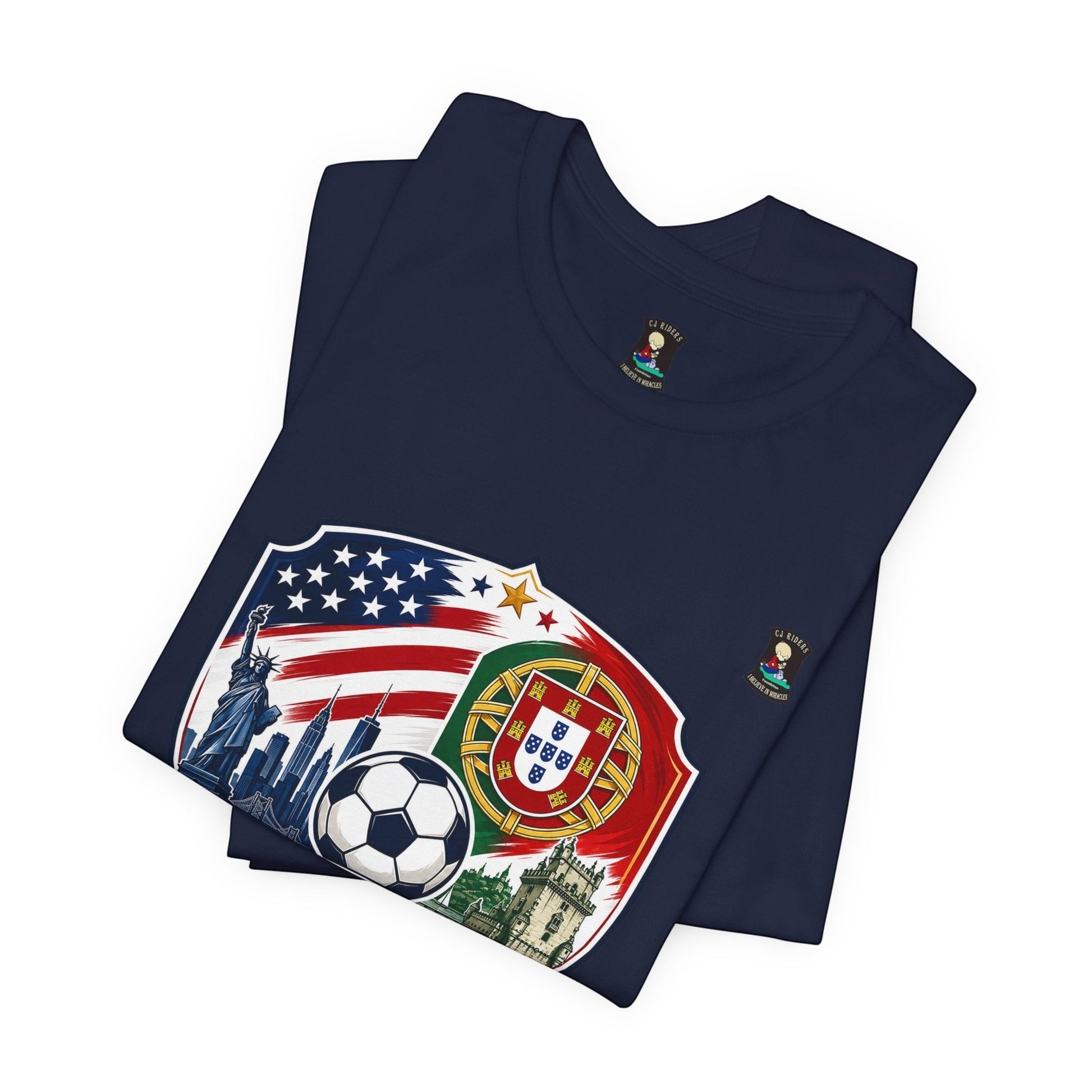 CJ Riders Foundation Store navy blue 100% cotton t-shirt with USA & Portugal soccer badge design, featuring Statue of Liberty, NYC skyline, soccer ball, and Portuguese crest.