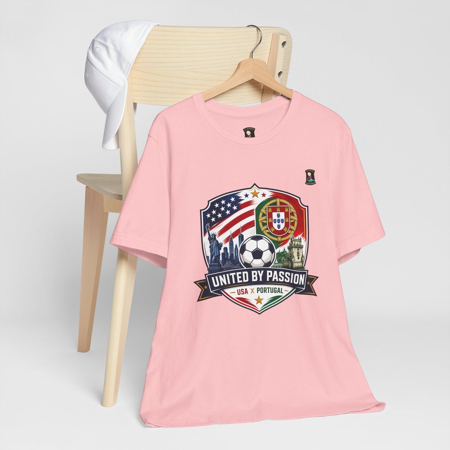 CJ Riders Foundation Store pink 100% cotton soccer t-shirt with USA & Portugal United by Passion 2026 graphic.