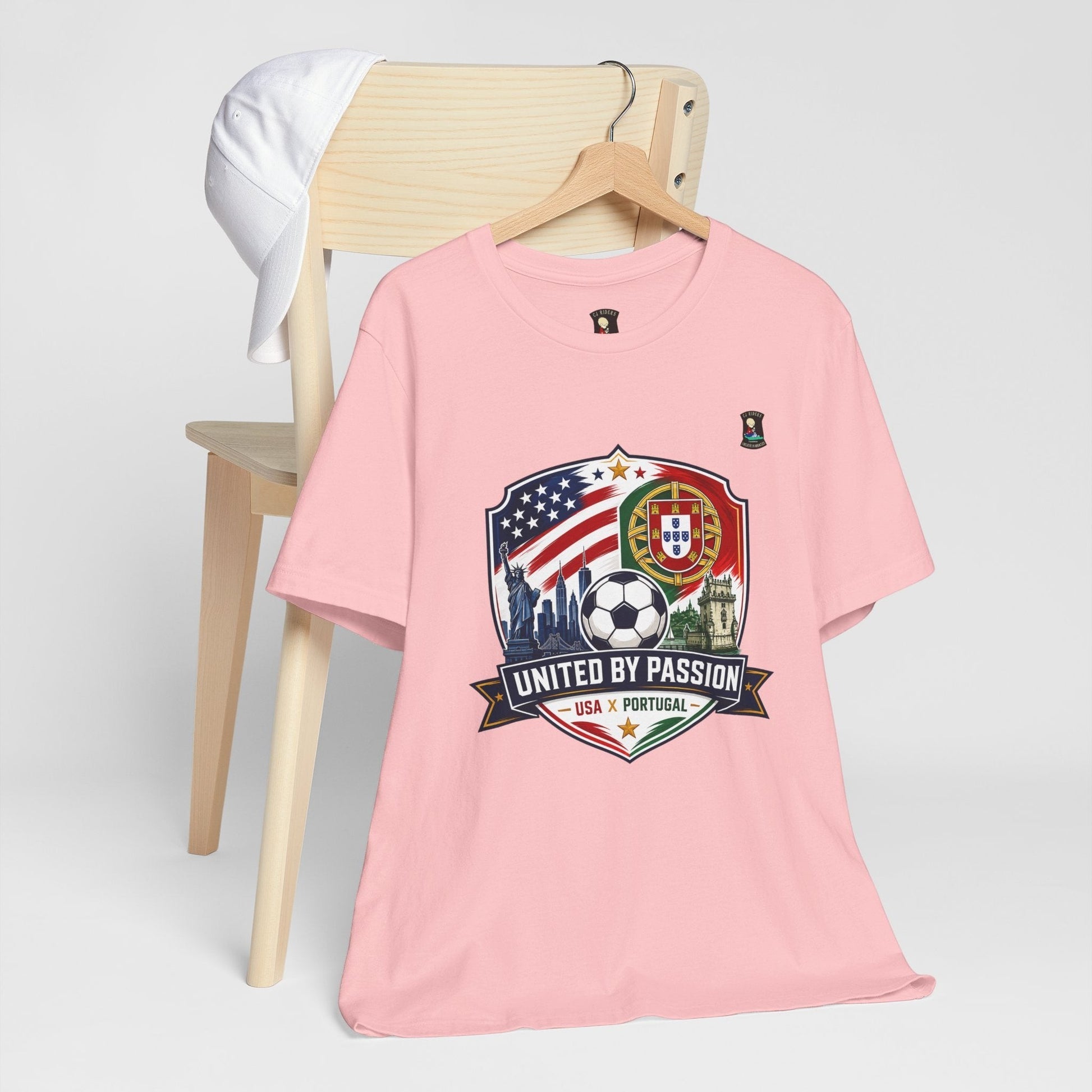 CJ Riders Foundation Store pink 100% cotton soccer t-shirt with USA & Portugal United by Passion 2026 graphic.