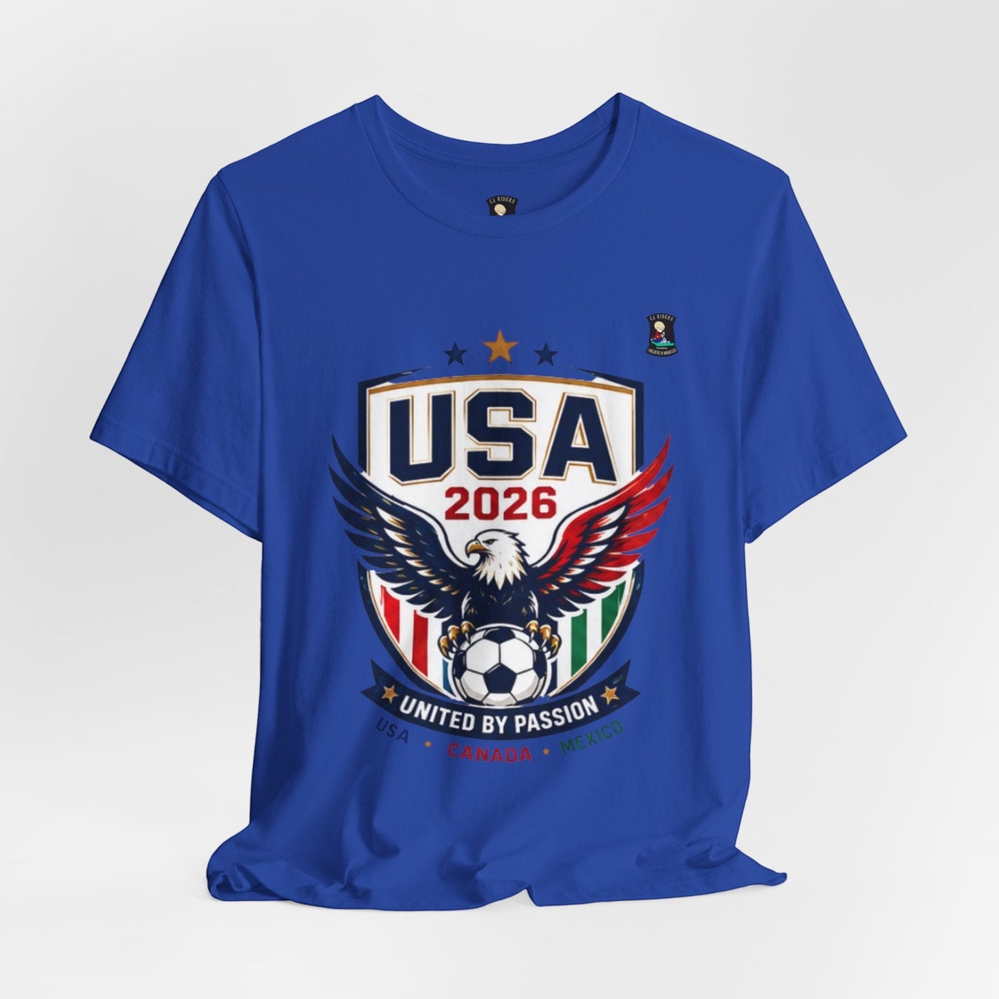 CJ Riders Foundation Store blue 100% cotton t-shirt with USA 2026 eagle and soccer graphic. Features "United by Passion" text.