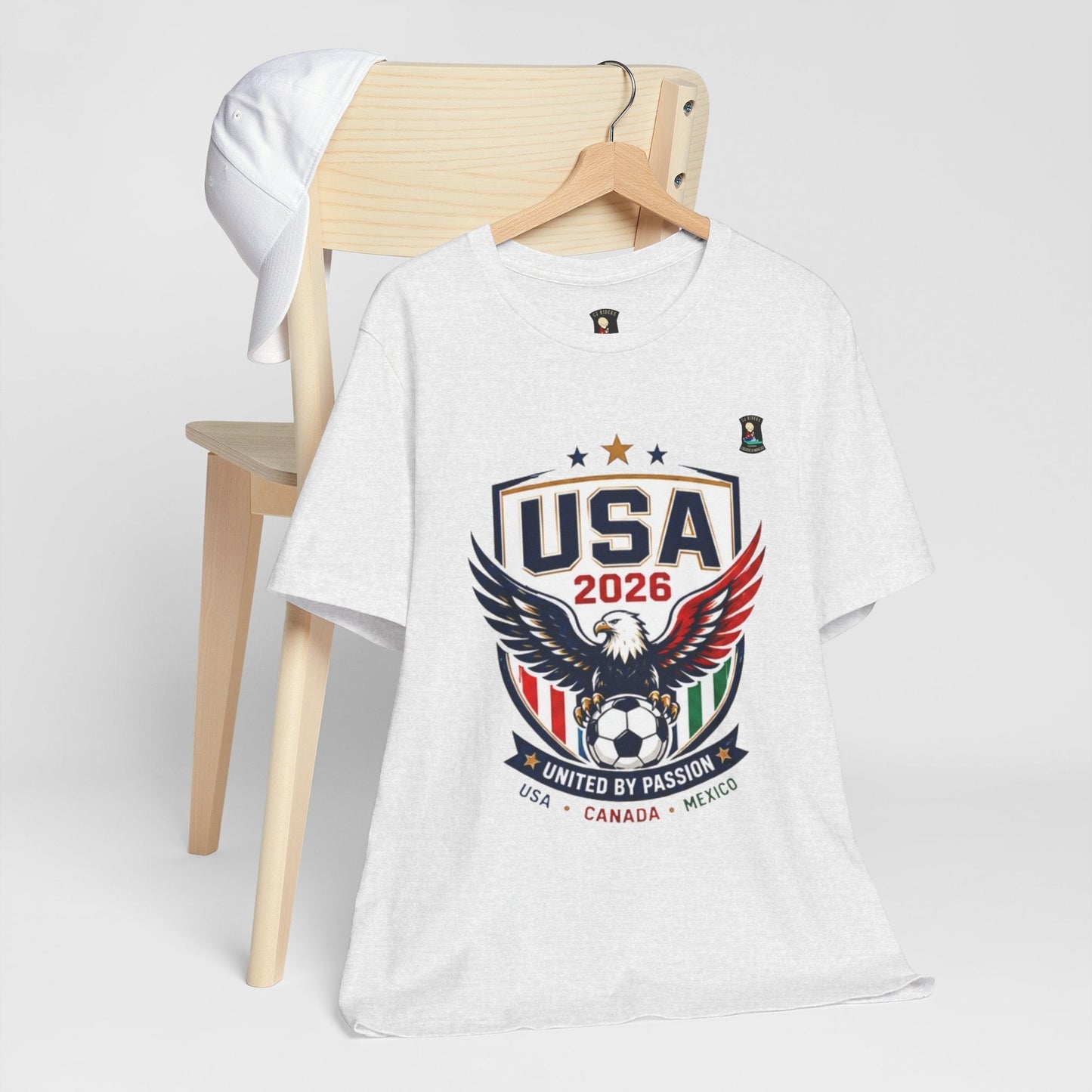 CJ Riders Foundation Store white 100% cotton USA United by Passion 2026 soccer t-shirt with eagle graphic.