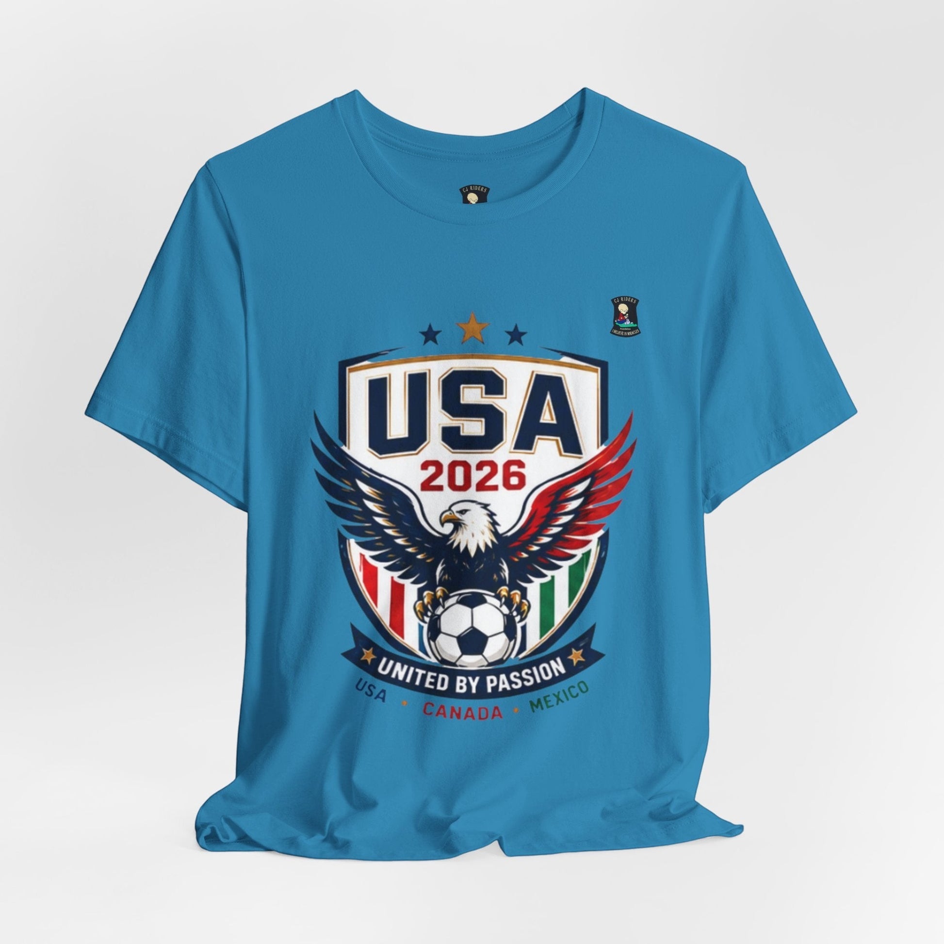CJ Riders Foundation Store blue 100% cotton t-shirt with USA 2026 eagle graphic and "United by Passion" text.